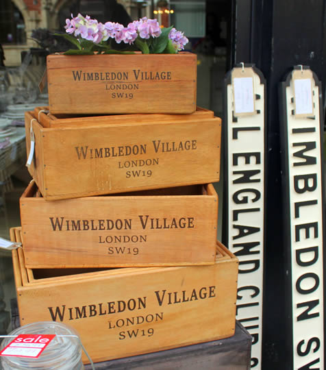 Wooden boxes with Wimbledon Village written on, filled with flowers