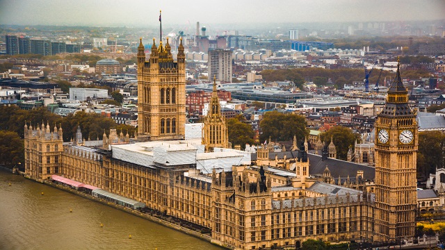 A high angle shot of the House of Parliament in London, juxtaposed with the river Thames