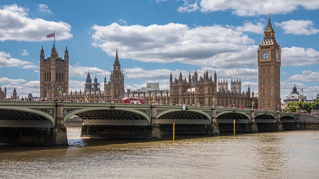 The Houses of Parliament and Big Ben, with a London red bus passing over Westminster bridge