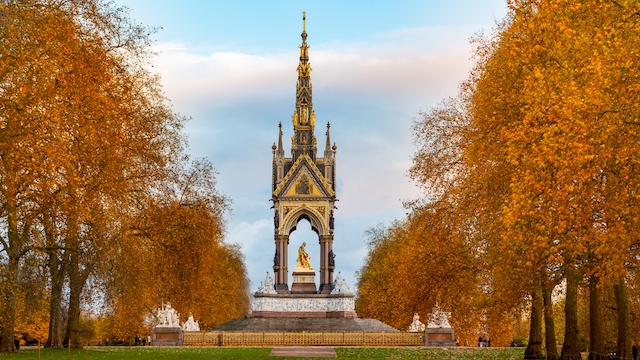 Albert Memorial at Kensington Gardens in London surrounded by trees with autumn foliage.