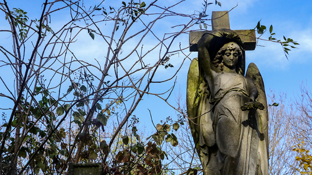 Statue of an angel in front of a cross at Abney Park Cemetery, London