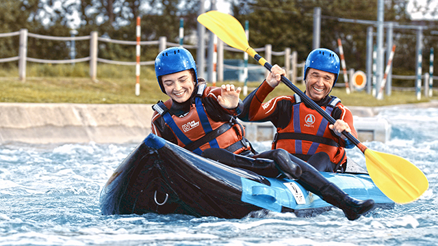 A woman and a man are kayaking along the river at Lee Valley Water Centre