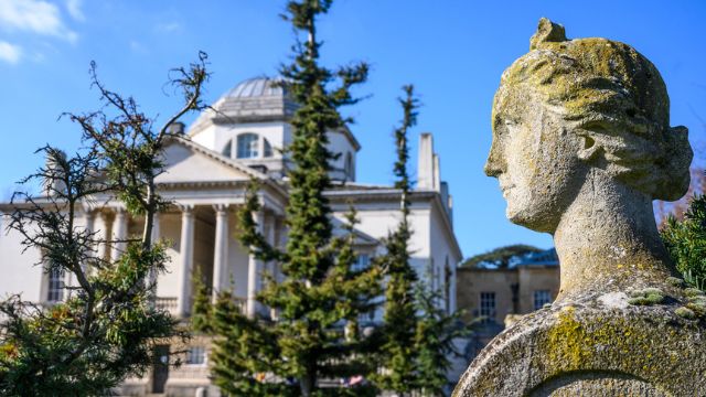 A statue stands beside the grand Chiswick House in Burlington London.