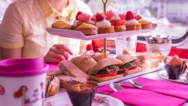 Un présentoir à gâteaux rempli de sandwiches et de gâteaux accompagne la visite en bus de l'Afternoon Tea de Brigit's Bakery.