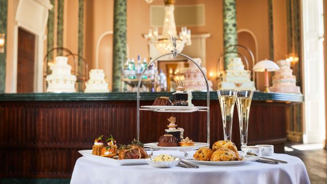 A table filled with delicious sweet treats and glasses of champagne and the Theatre Royal Drury Lane Champagne Afternoon tea in the Grand Saloon.