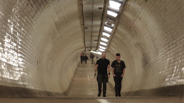 Two men walking through Greenwich Foot Tunnel.
