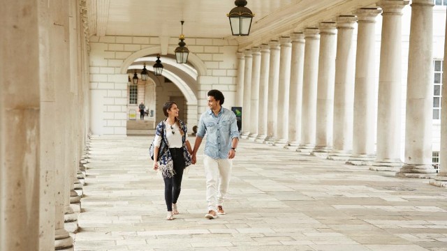 A couple walk in the colonnades of Queen's House in Greenwich.
