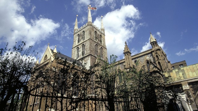 Outside the gates and looking up at Southwark Cathedral against blue skies.