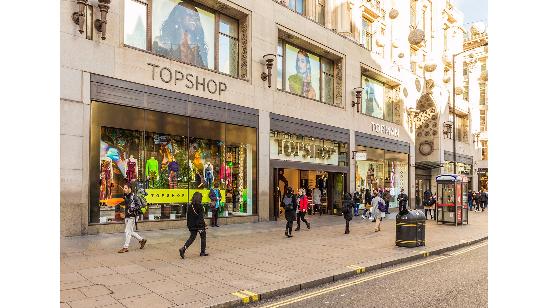 A view of the outside of Topshop on Oxford Street with people walking past.