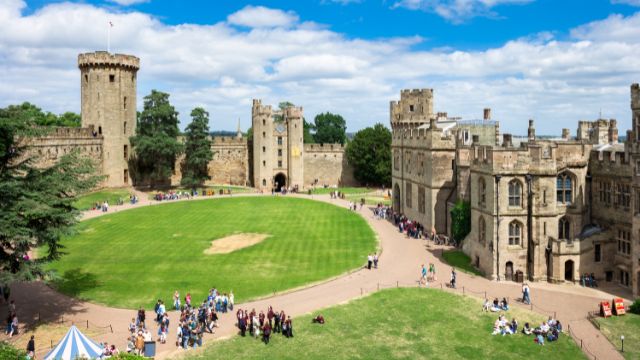 Les visiteurs se promènent dans le parc du château de Warwick, site historique. 