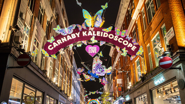 Weihnachtslichterinstallation über der Carnaby Street in London. Eine Reklame mit den Worten "Carnaby Kaleidoscope".
