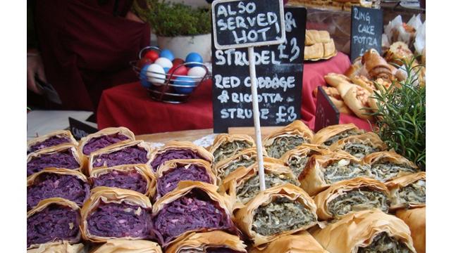 A close-up of a stall selling savoury strudels, which are cut in half and displayed.