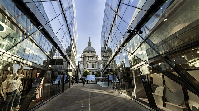 St Paul's Cathedral, in the background, is reflected in the glass walls on both sides of a narrow alleyway at One New Change.