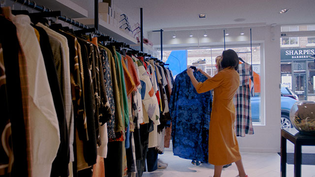 A woman browsing the clothing rails at 69b Boutique.