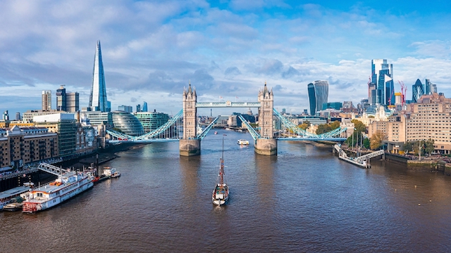Aerial view of Tower Bridge and the river Thames on partly cloudy in London.