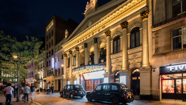 Palladium Theatre in London's West End at night with cabs waiting outside the entrance.