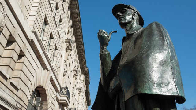 Sherlock Holmes statue outside Baker Street station on a sunny day.