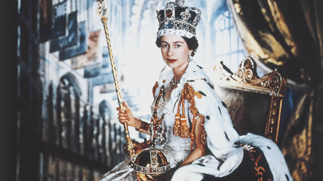 Portrait de sa Majesté la Reine Elizabeth II le jour de son couronnement, assise sur le trône et portant une cape d'hermine, les joyeaux de la couronne , ainsi que l'orbre et le sceptre. 