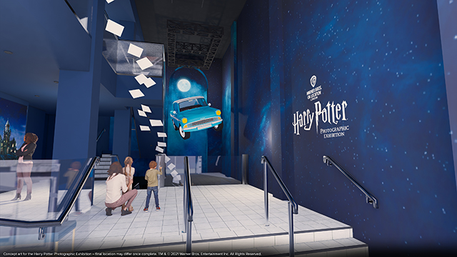 A computer-generated image of the entrance to The Harry Potter Photographic Exhibition, showing a lady with two children, a blue wall with the name of the exhibition and a car and pieces of paper suspended in the air.
