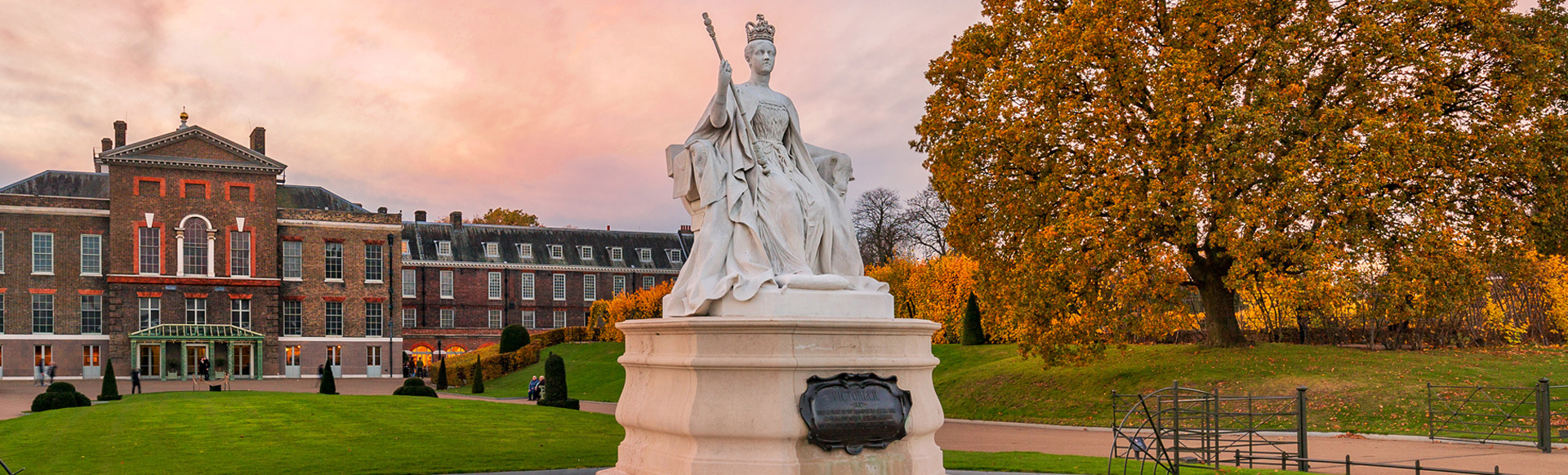 Kensington Palace and the statue of Queen Victoria at sunset.
