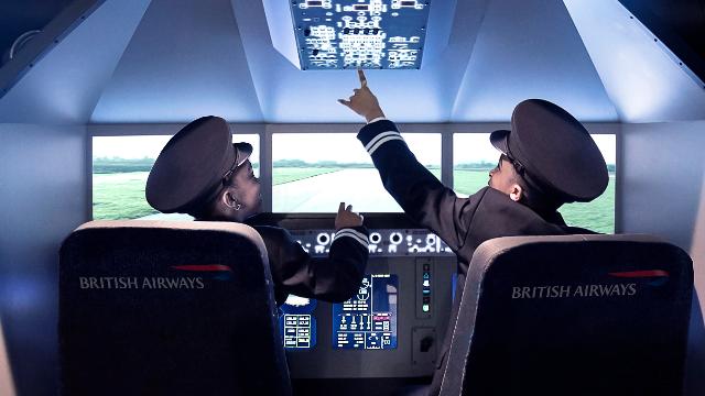 Two boys, dressed in pilot uniforms, play in the cockpit of a plane at Kidzania.