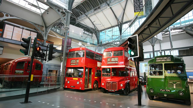 Deux bus rouges et un bus vert exposés au London Transport Museum.