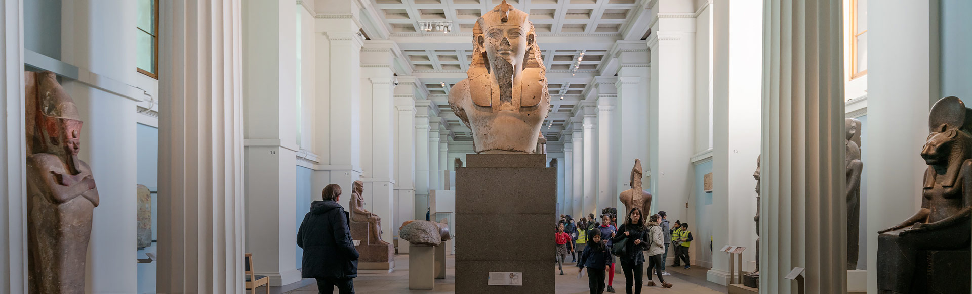 interior of the British Museum'S Egyptian Hall with Egyptian statues and museum visitors. © London and Partners/Jon Reid