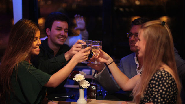 A group of people cheers champagne glasses.