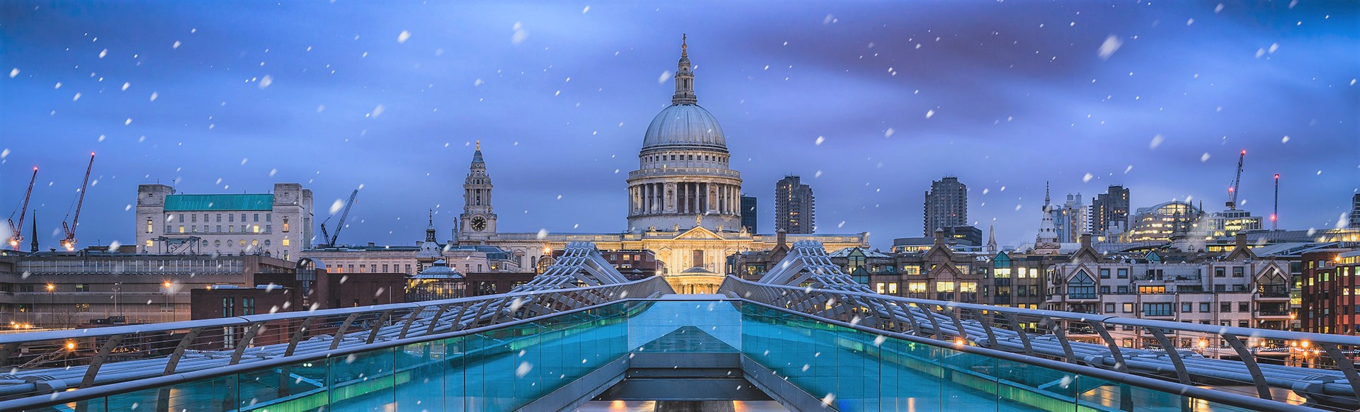 A view of St Paul's Cathedral on a snowy evening from the Millennium Bridge