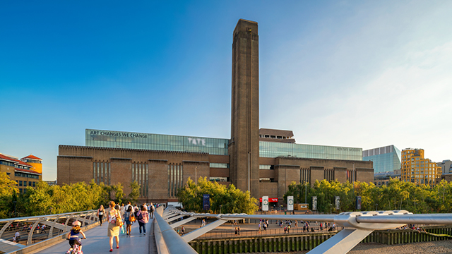 The facade of Tate Modern, including it's striking brick tower, taken from Millennium Bridge on a bright day.