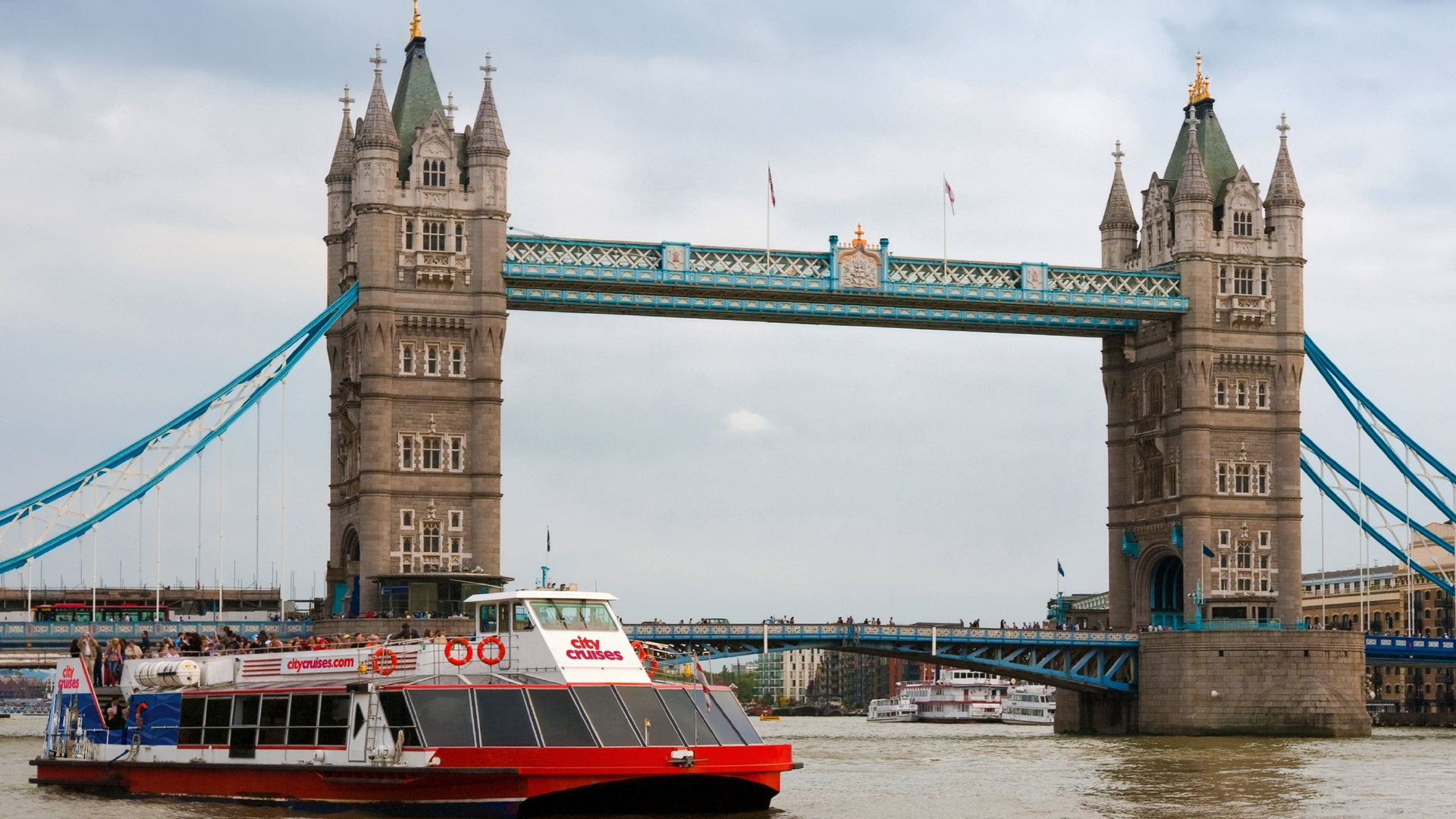 City Cruises boat cruising past Tower Bridge on the river Thames.