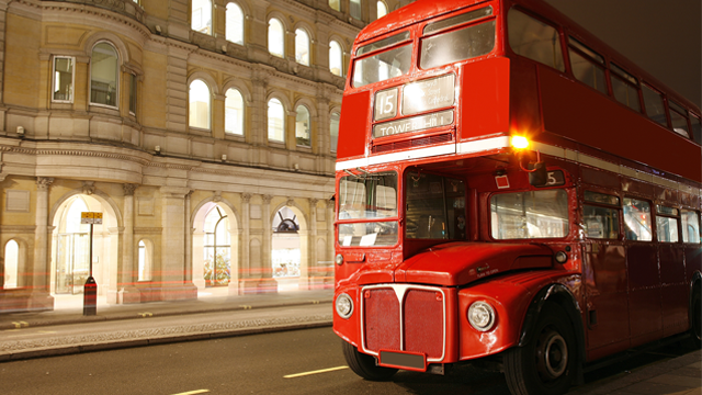 Vintage red double-decker bus at night, part of the afternoon tea bus tour at Harrods in London.