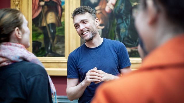 A guide gives a highlights tour for visitors to The National Gallery in London.