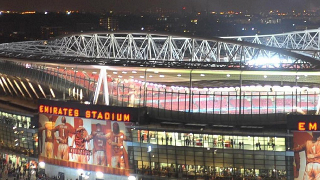 Das Arsenal-Emirates-Fußballstadion bei Nacht für ein Spiel beleuchtet.