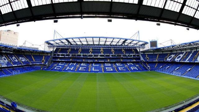 Chelsea FC Stadium pitch and empty blue seats.