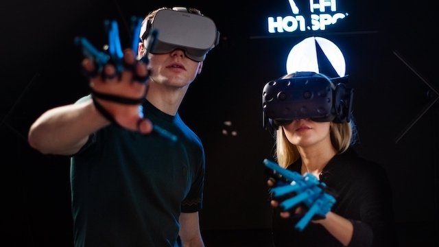A man and a woman wear virtual reality headsets at a gaming space in London.