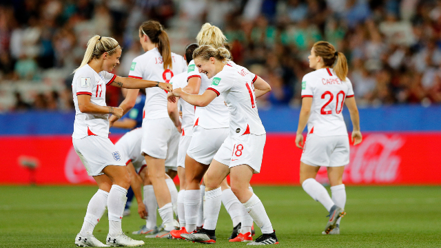 Image of the women's England team on a football pitch. 