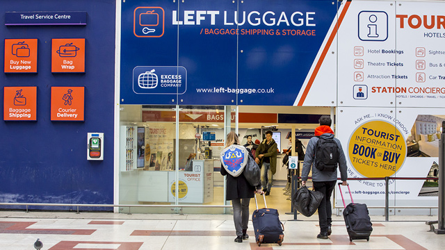 Two people walk into a left luggage facility at Victoria Station in London