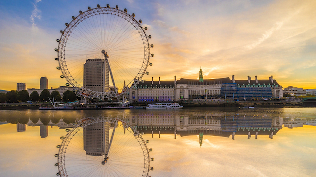 London Eye reflected on the river Thames during a bank holiday weekend in the UK