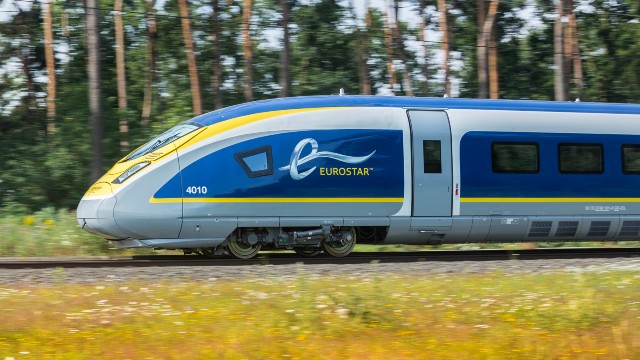A Eurostar train in motion, travelling through countryside.