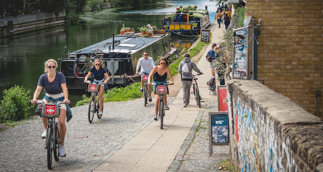 Cyclists ride on a canal towpath in London