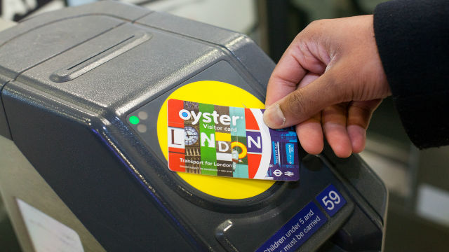 Passenger uses a colourful Visitor Oyster card at the Tube gate in London