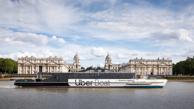 The Uber Boat by Thames Clippers river bus floats along the river Thames past the Old Royal Naval College. 