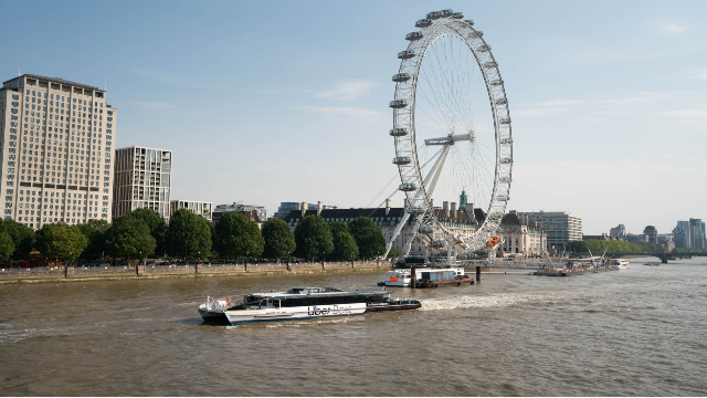 The Jupiter clipper operated by Uber Boat by Thames Clippers sails past The London Eye.