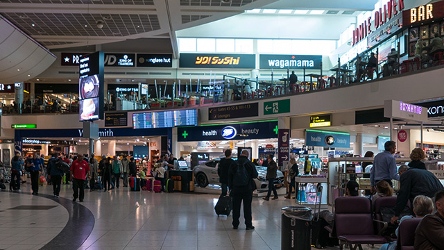 Passengers wait in the terminal at Gatwick Airport in London.