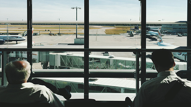Deux passagers sont assis en regardant des avions sur la piste de l'aéroport d'Heathrow.