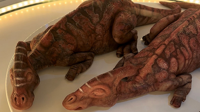 Two baby dinosaurs seem to be sleeping in the Hammond Lab at Jurassic World