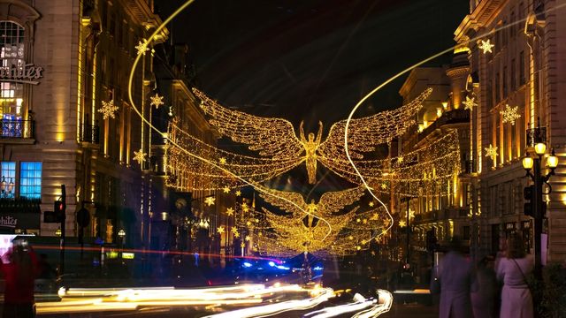 Leuchtend orangefarbene Lichter in Form eines Engels beleuchten die Regent Street in London auf der Christmas Lights Bus Tour. 