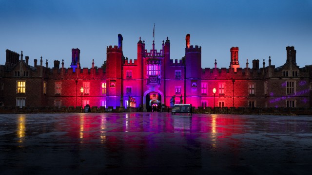 The exterior of Hampton Court Palace bathed in colourful lighting for the Palace of Light festival