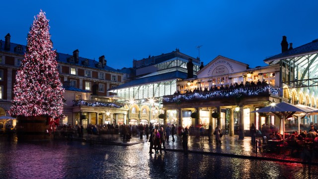 Tall, sparkling Christmas tree outside Covent Garden in the evening 